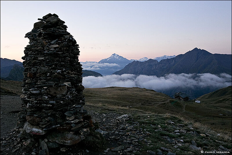 Amanhecer  no Col de la Croix-du-Bonhomme (2.479 m) com o Mont Pourri (3.779 m) no centro e o refúgio no canto inferior direito.